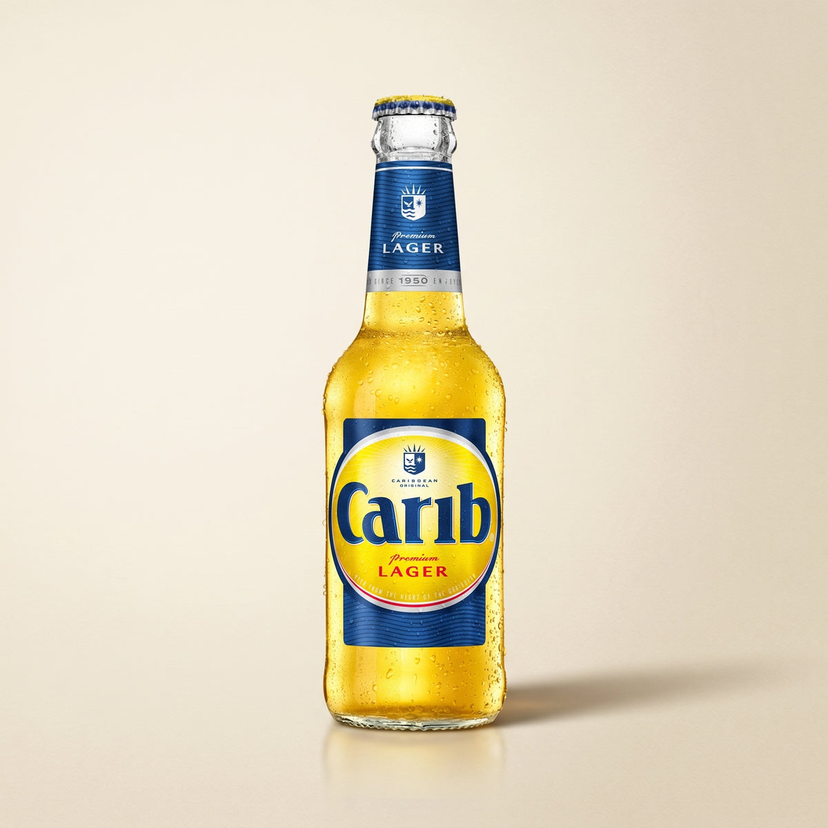 Carib Premium Lager bottle on a bone studio surface