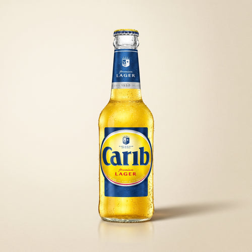 Carib Premium Lager bottle on a bone studio surface