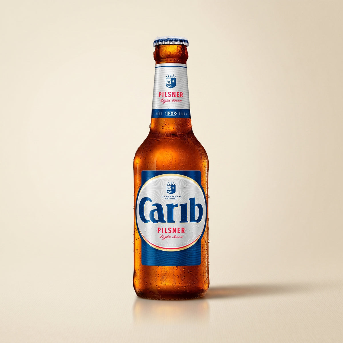Carib Pilsner bottle on a bone studio surface