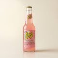 Pink Ting grapefruit soda bottle on a bone studio surface