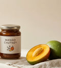 Bellyful Mango Chutney: a jar of dark spiced mango chutney beside a halved mango.