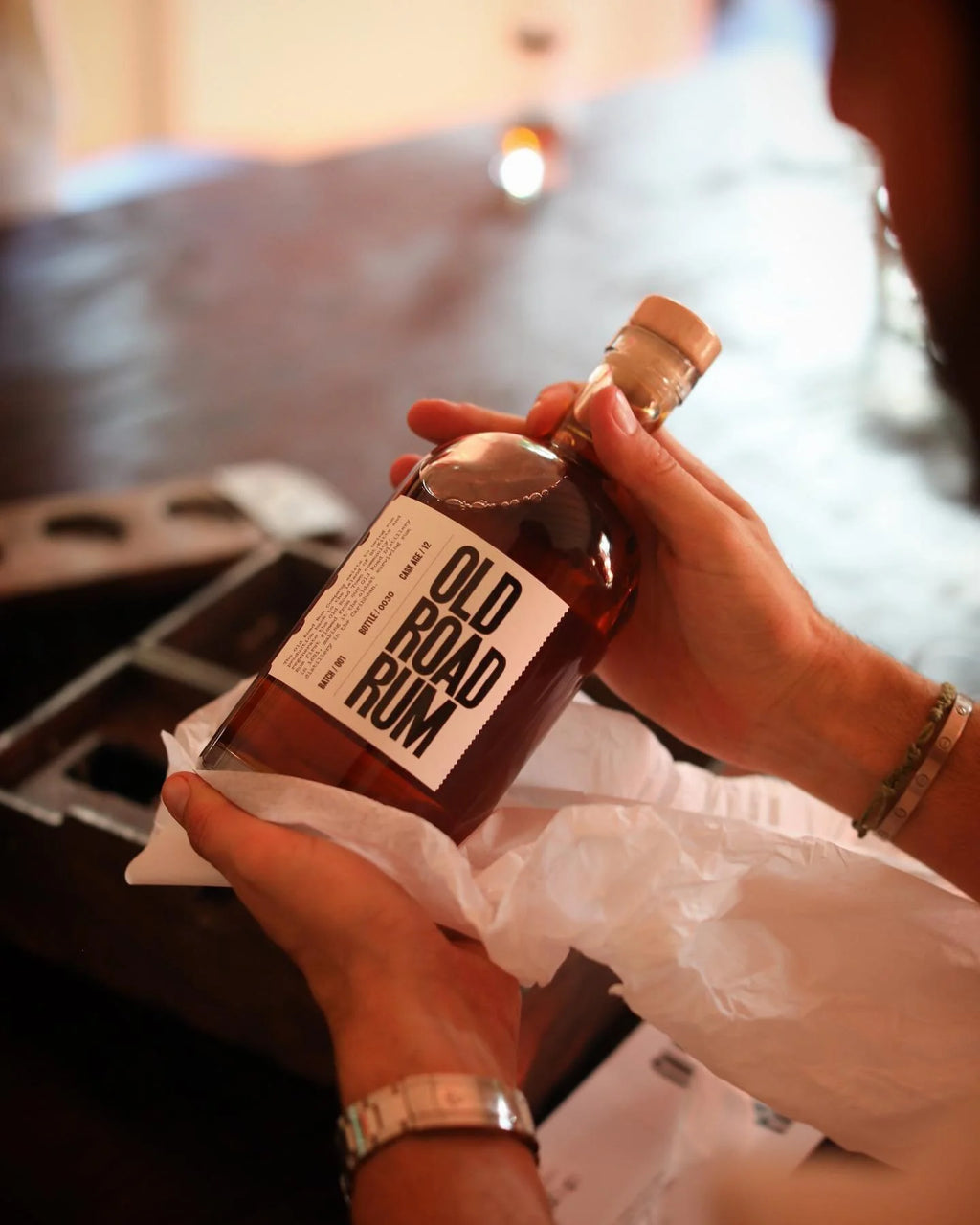 Old Road Rum 12-year bottle in dappled light, palm shadow on stone, Wingfield Estate, St. Kitts